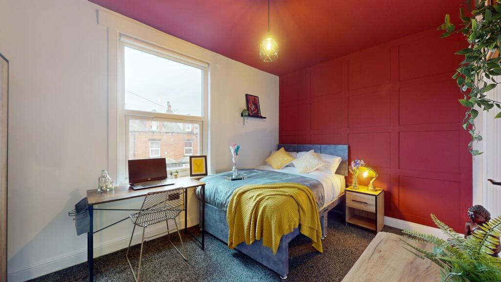 This cozy double bedroom features a comfortable...