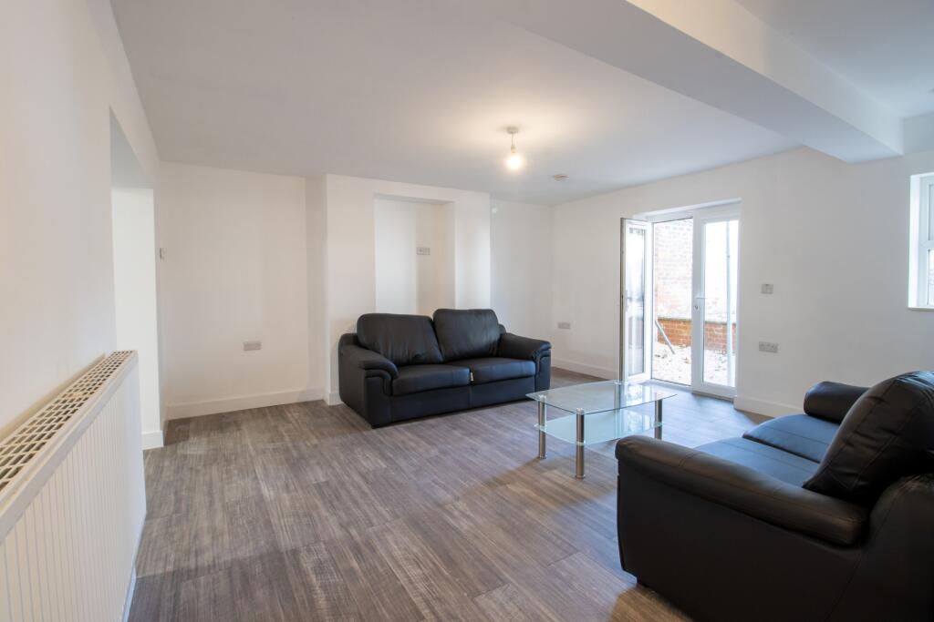 Bright and spacious living room with large wind...