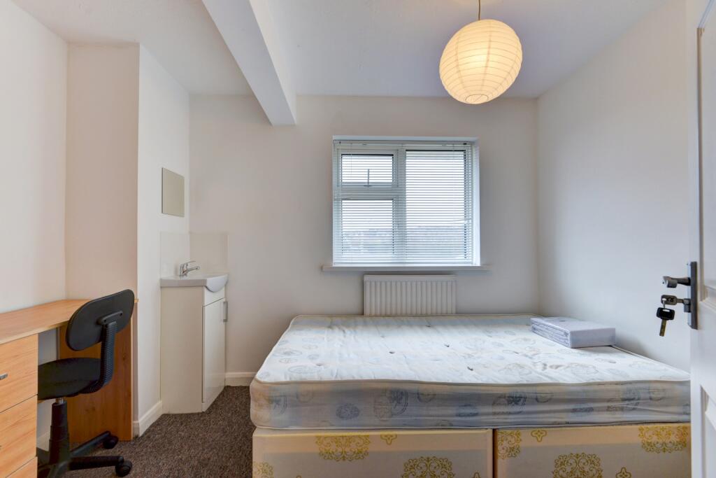 Bright and clean student bedroom featuring a ne...