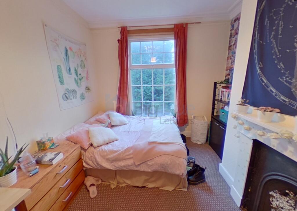 Cozy bedroom featuring a large window with brig...