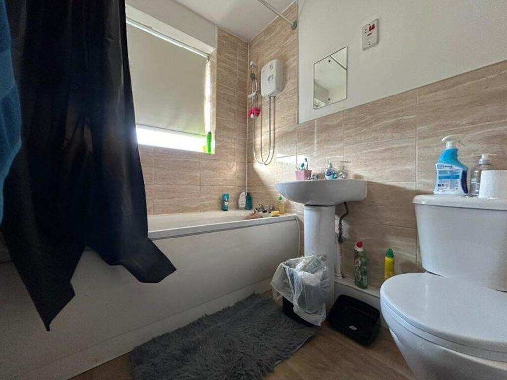 A bright and tidy bathroom featuring a bathtub ...
