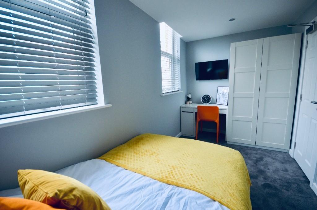 A stylish double bedroom featuring a cozy bed w...