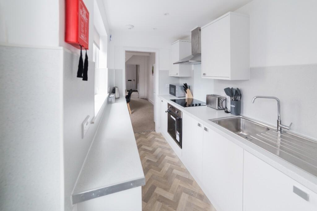 Modern kitchen featuring sleek cabinetry, ample...