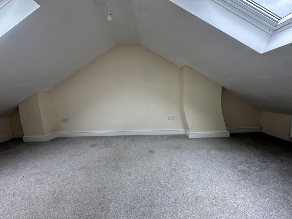 Spacious double bedroom featuring large skyligh...