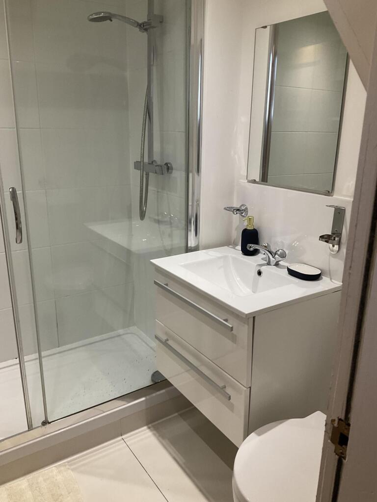Modern bathroom featuring a clean and sleek gla...