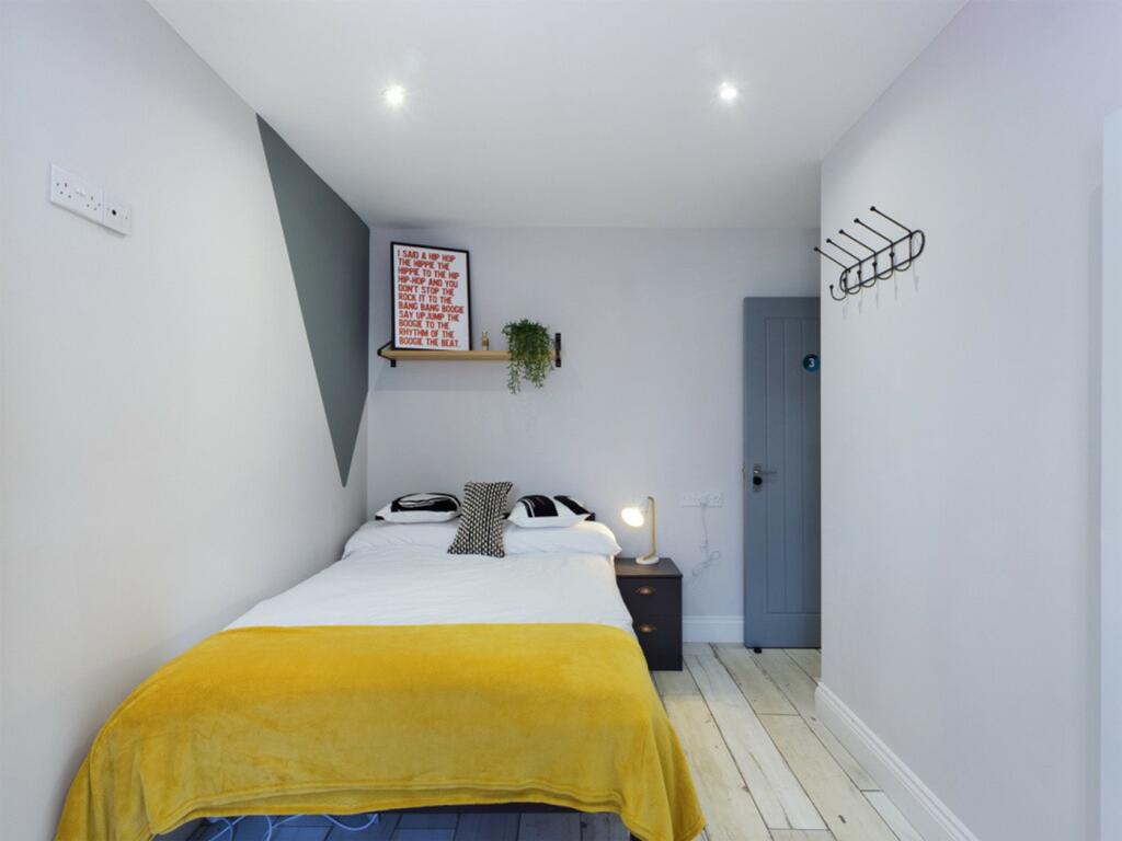 A bright and inviting double bedroom with styli...