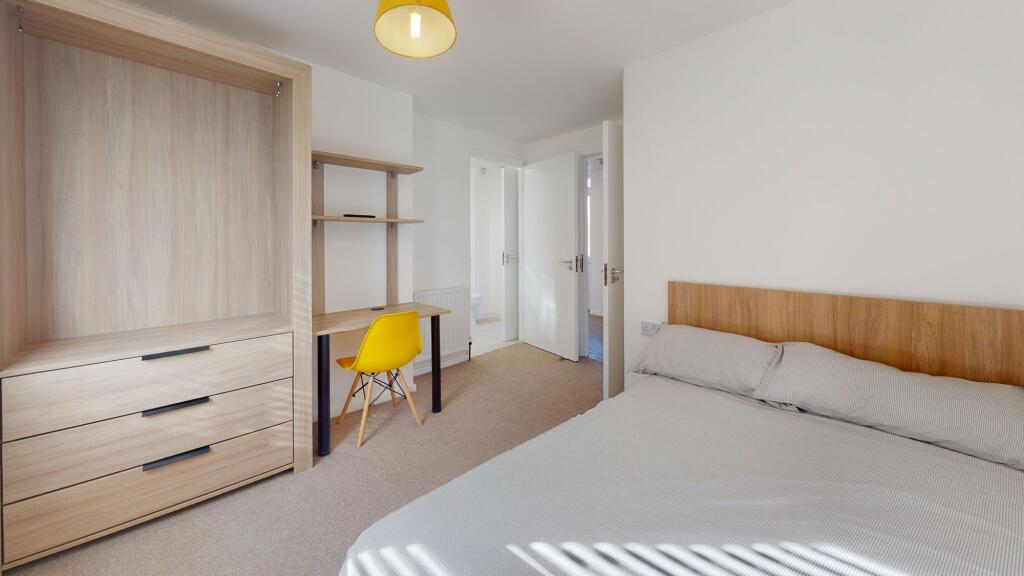 Bright and welcoming double bedroom featuring a...