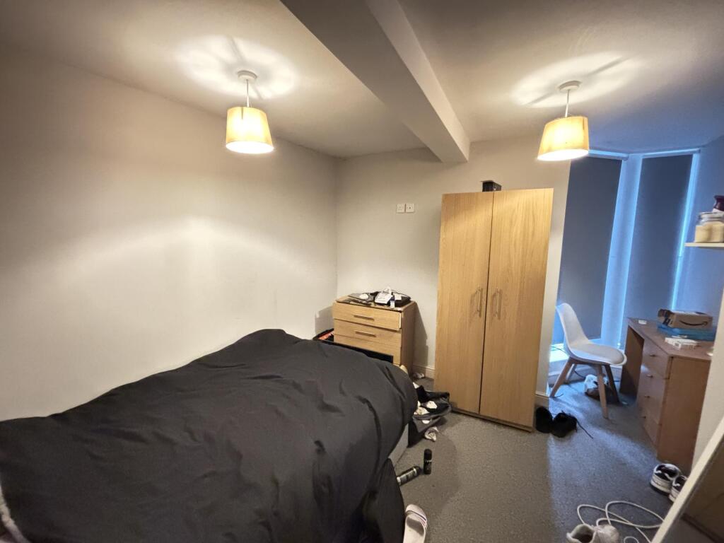 A cozy bedroom featuring a single bed with a da...