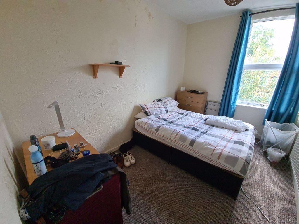 A cozy student bedroom featuring a single bed b...