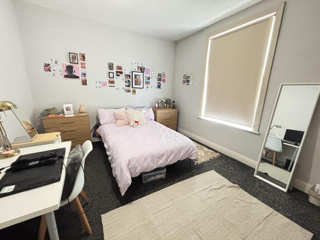 A cozy and well-maintained bedroom featuring a ...