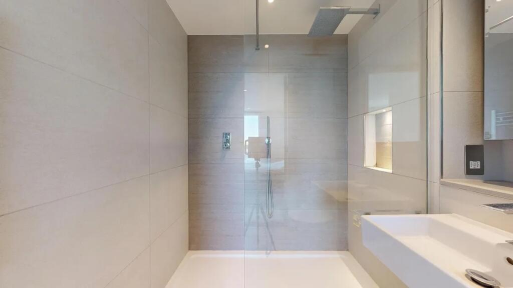 A sleek and modern bathroom featuring a spaciou...