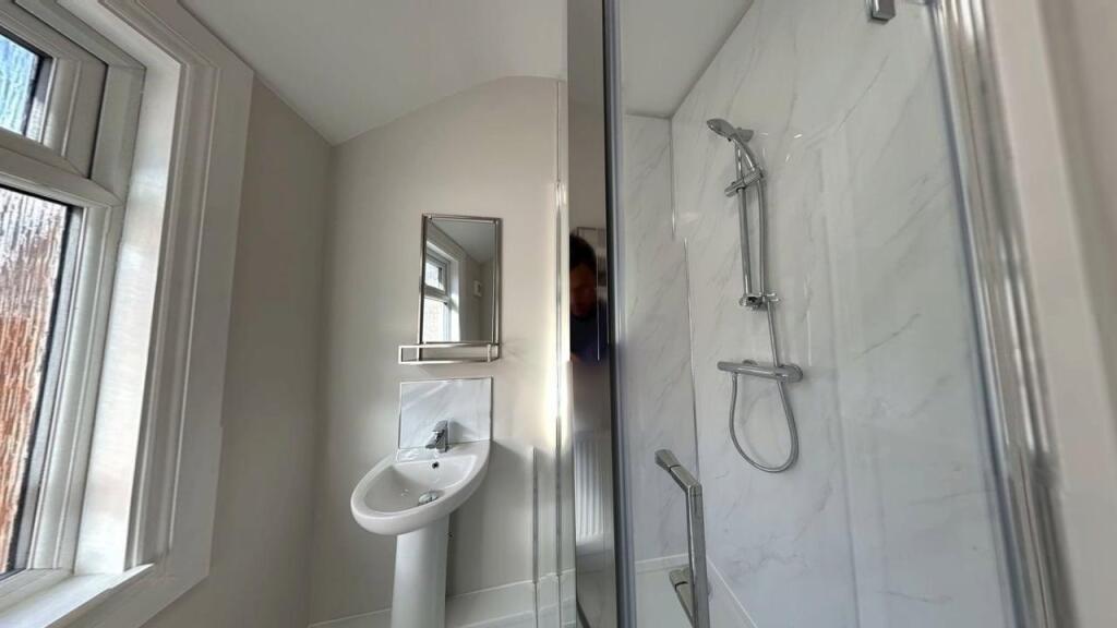 A modern, clean bathroom featuring a shower wit...
