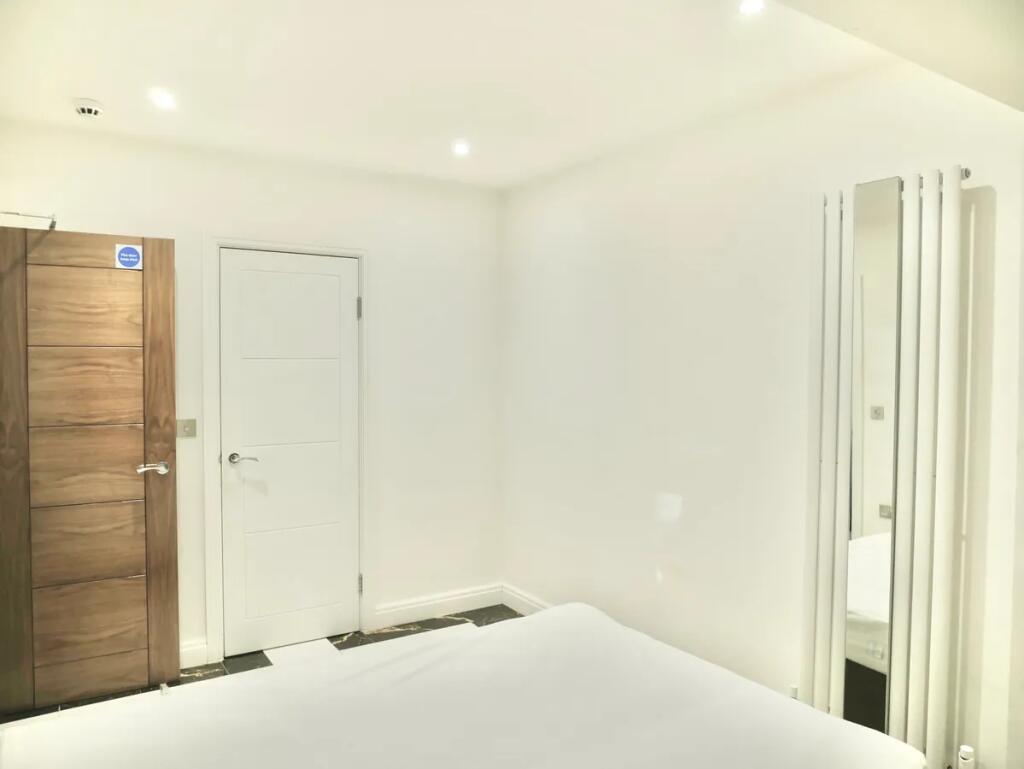 A clean and modern double bedroom featuring bri...