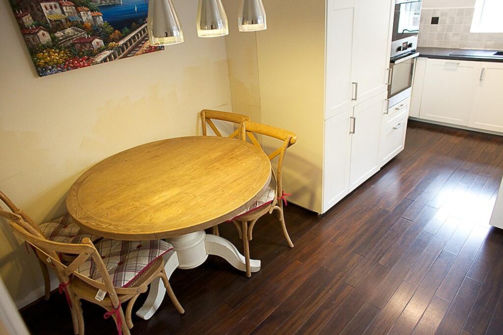 A charming kitchen featuring a round wooden din...
