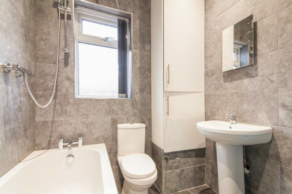 A modern and clean bathroom featuring a bath an...
