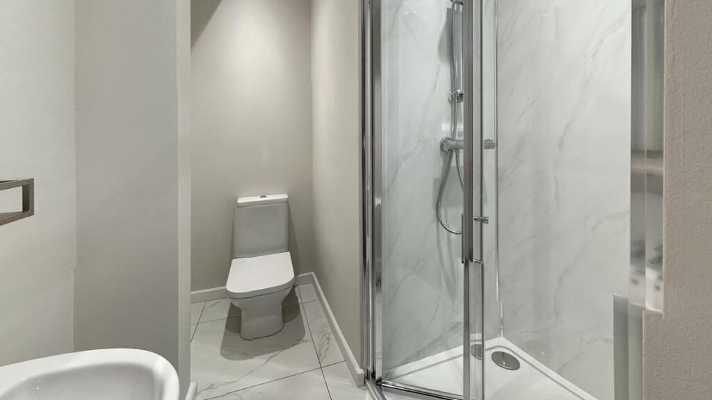 A modern, clean bathroom with a spacious shower...