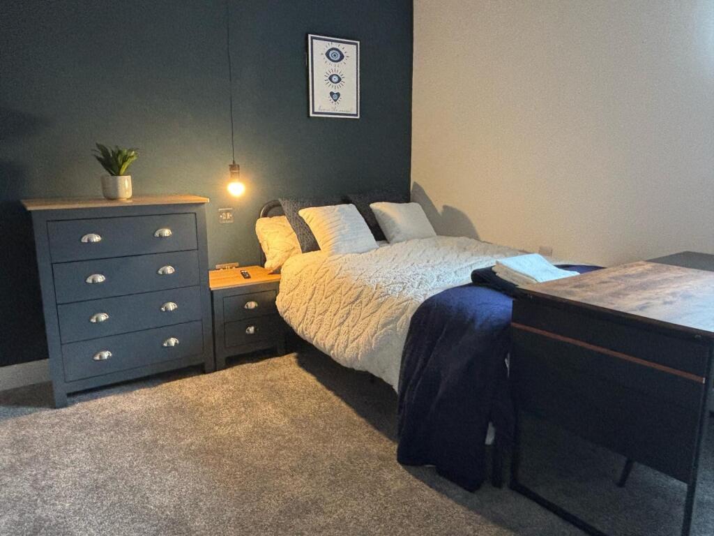 This stylish double bedroom features a cozy bed...