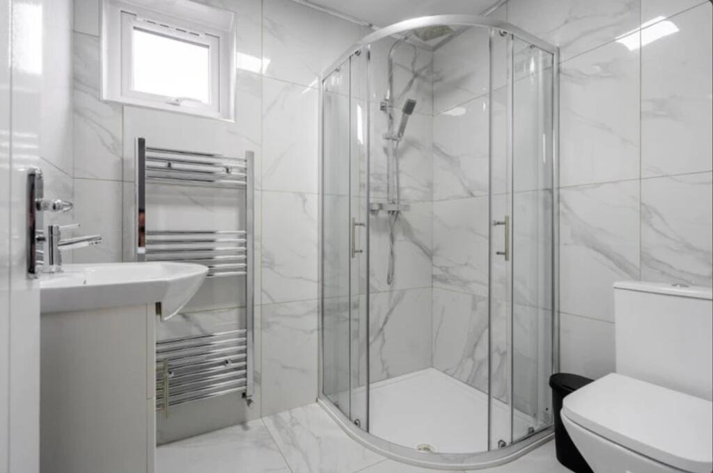 A modern bathroom featuring a stylish shower en...