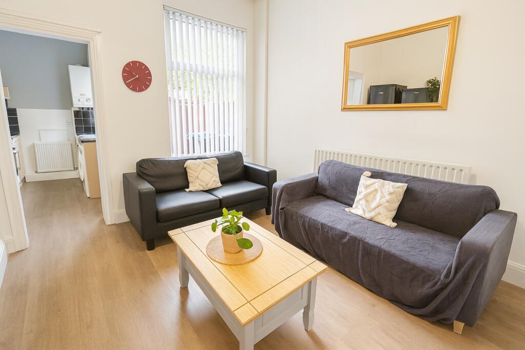 A bright and tidy living room featuring two com...