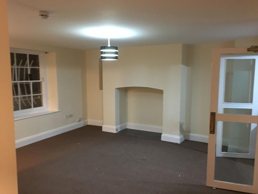 Spacious, neutral-toned living room with a cent...