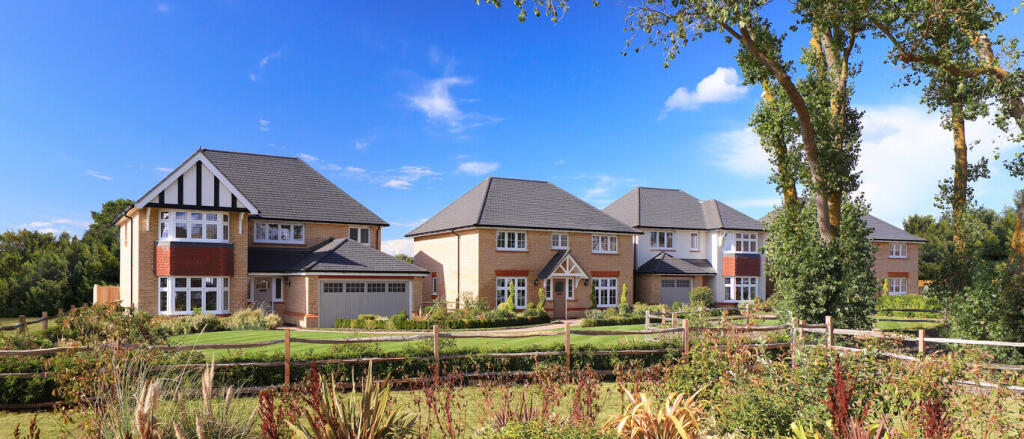 Modern detached houses with landscaped gardens under a blue sky at Redrow Millview Park in the UK at