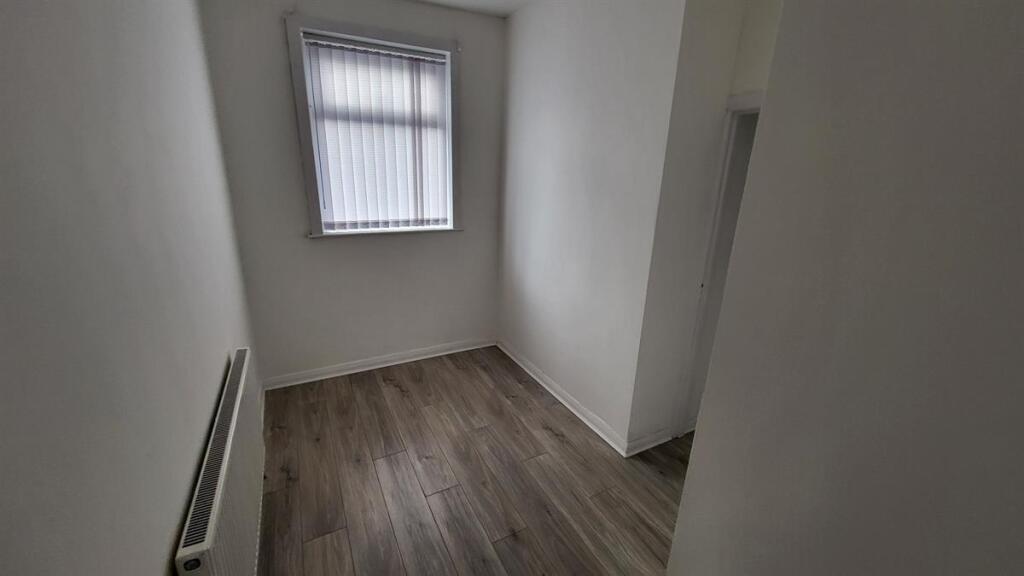 Neat, narrow room with wood-effect flooring, fr...