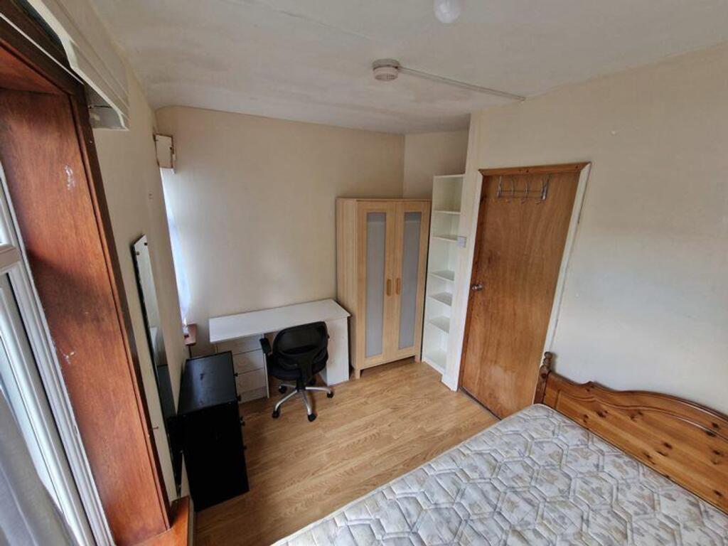 A spacious and tidy double bedroom featuring a ...