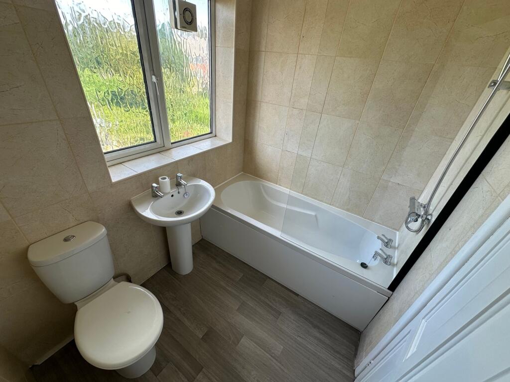 Bright and clean bathroom suite featuring a ful...