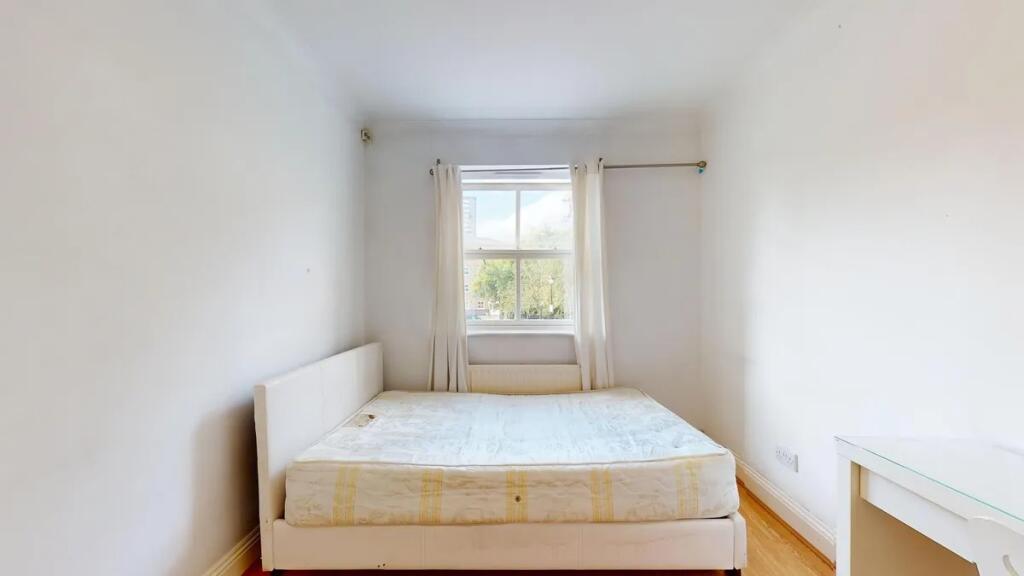 A bright double bedroom featuring a comfortable...