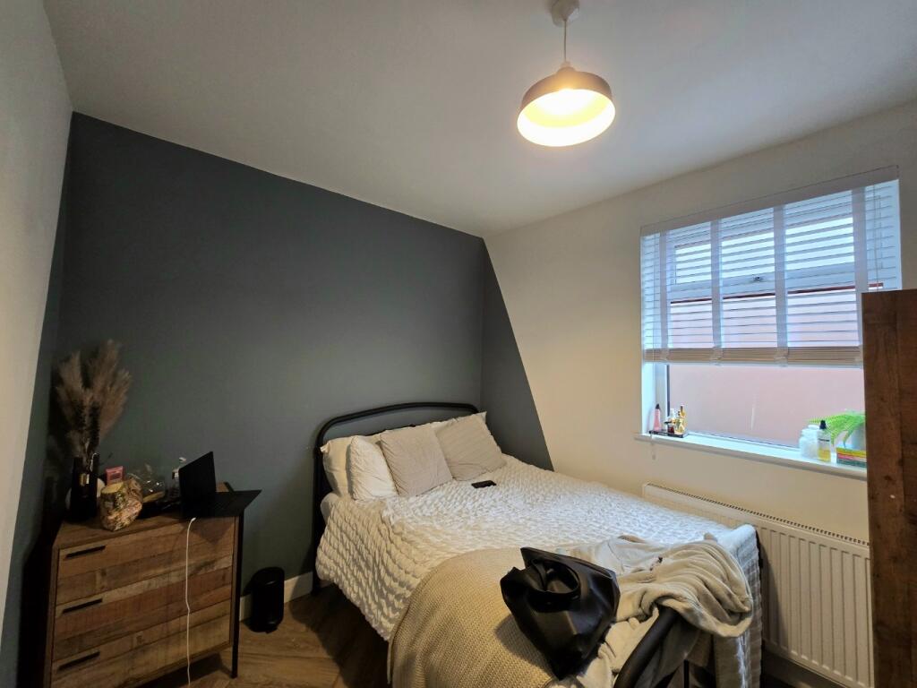 A spacious master bedroom featuring a comfortab...