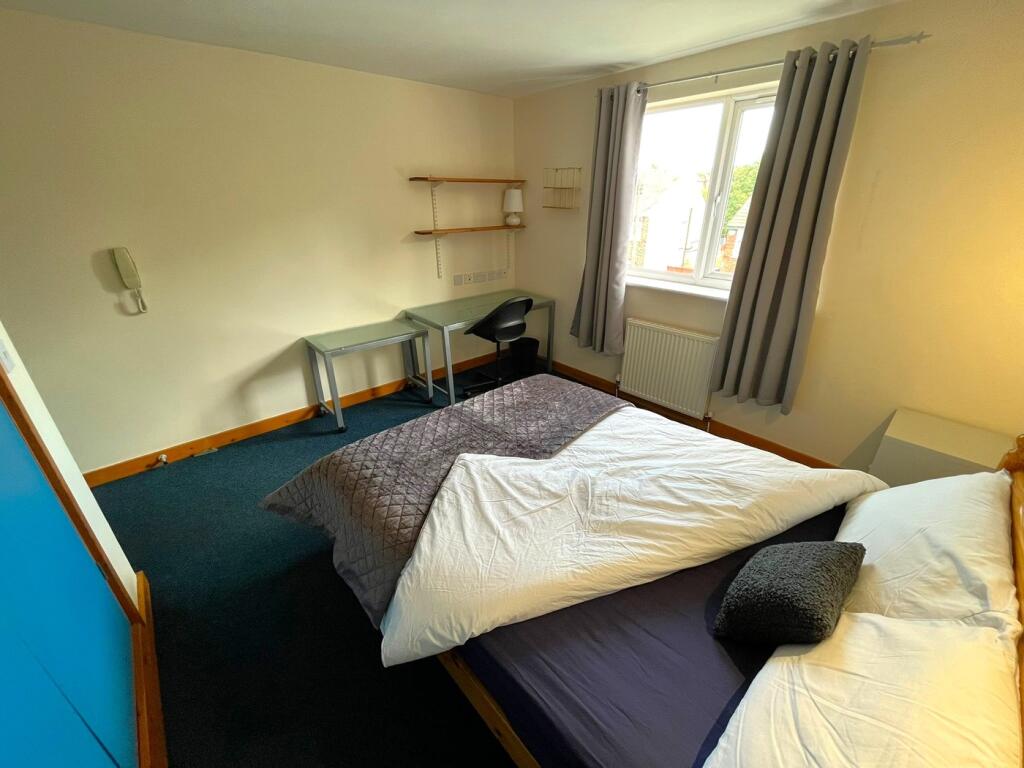 A spacious and well-lit double bedroom featurin...