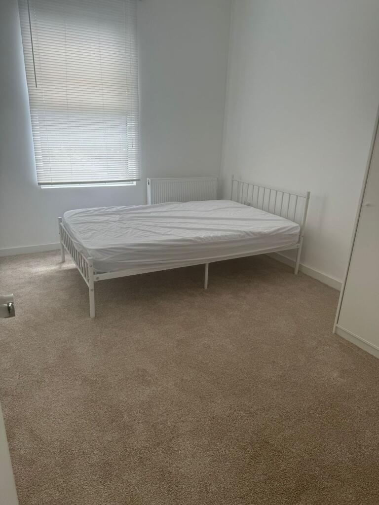 A bright and tidy double bedroom with neutral c...