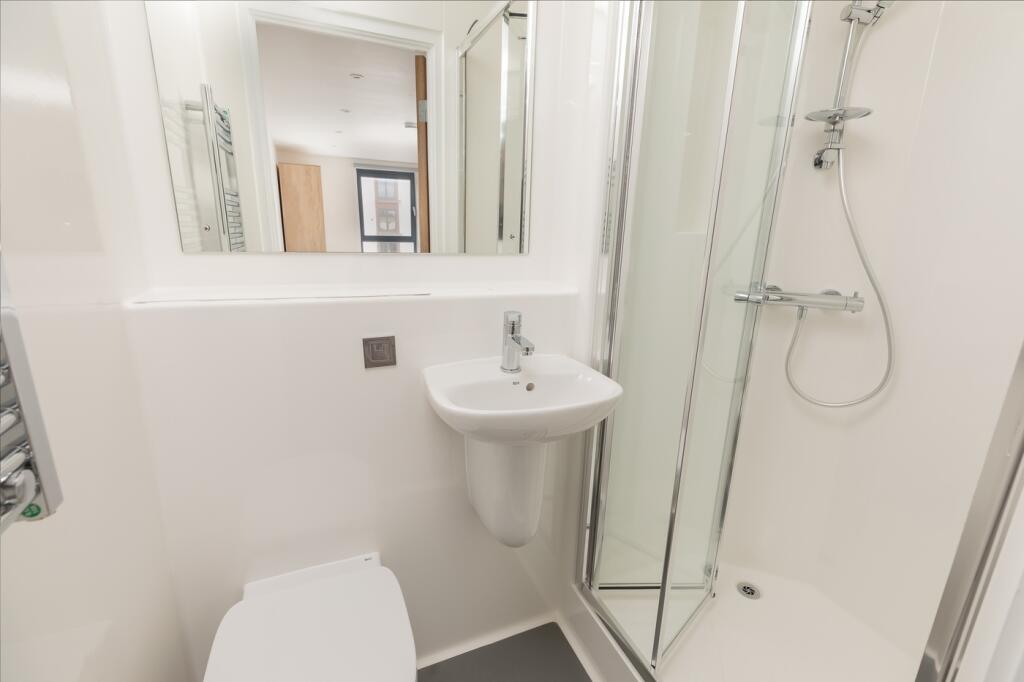 A modern and pristine bathroom featuring a slee...