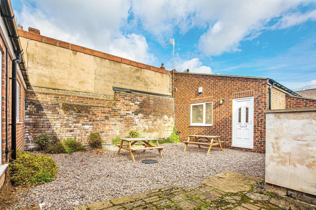 Private paved courtyard with two picnic benches...