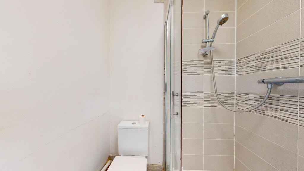 A clean, modern bathroom with a shower area fea...