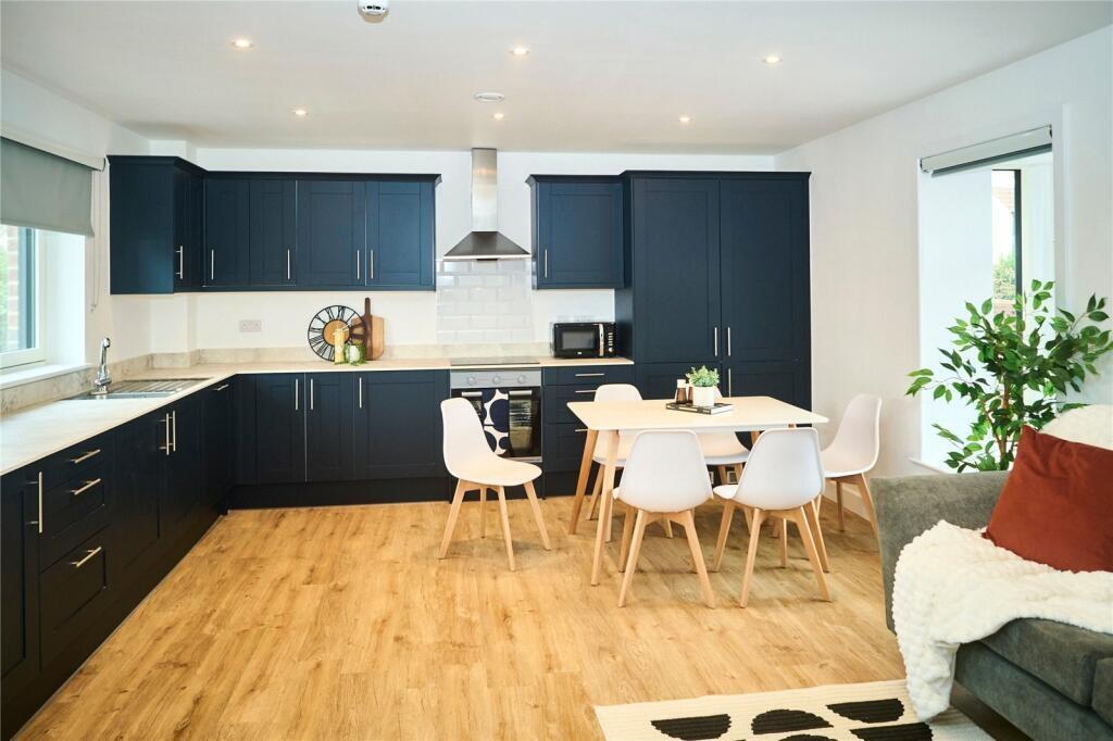 Bright and modern kitchen with sleek navy cabin...