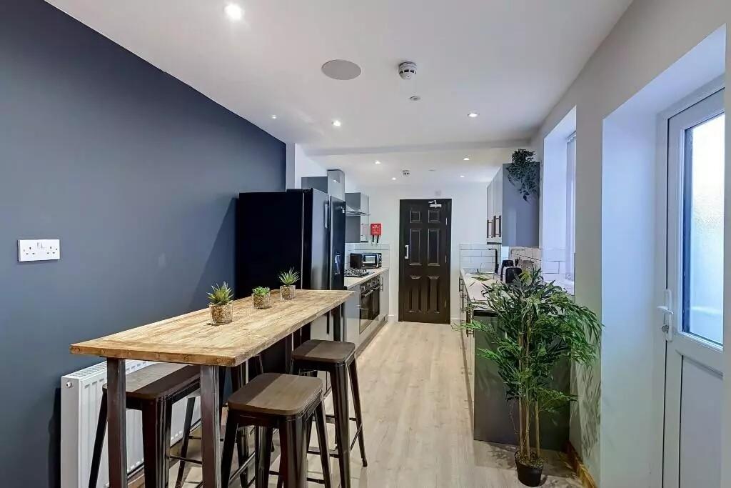 A sleek modern kitchen featuring a long wooden ...