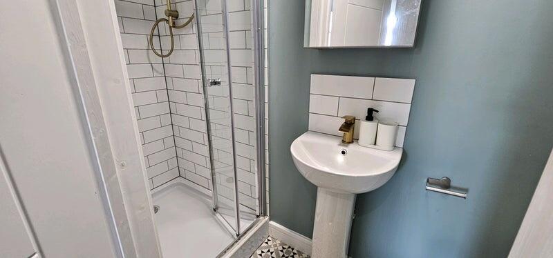 A modern bathroom featuring a spacious walk-in ...