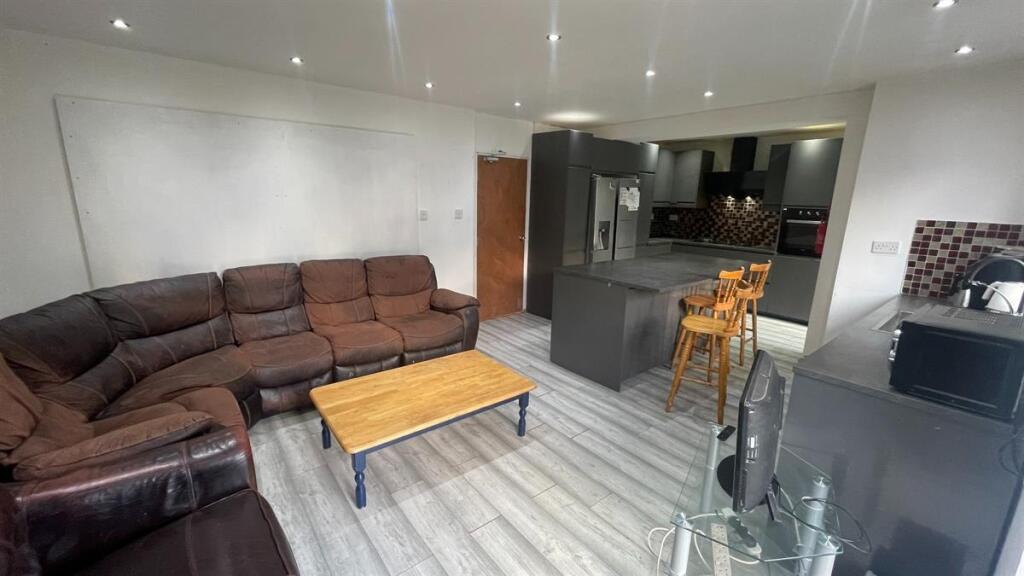 Bright, open-plan living area with a large L-sh...