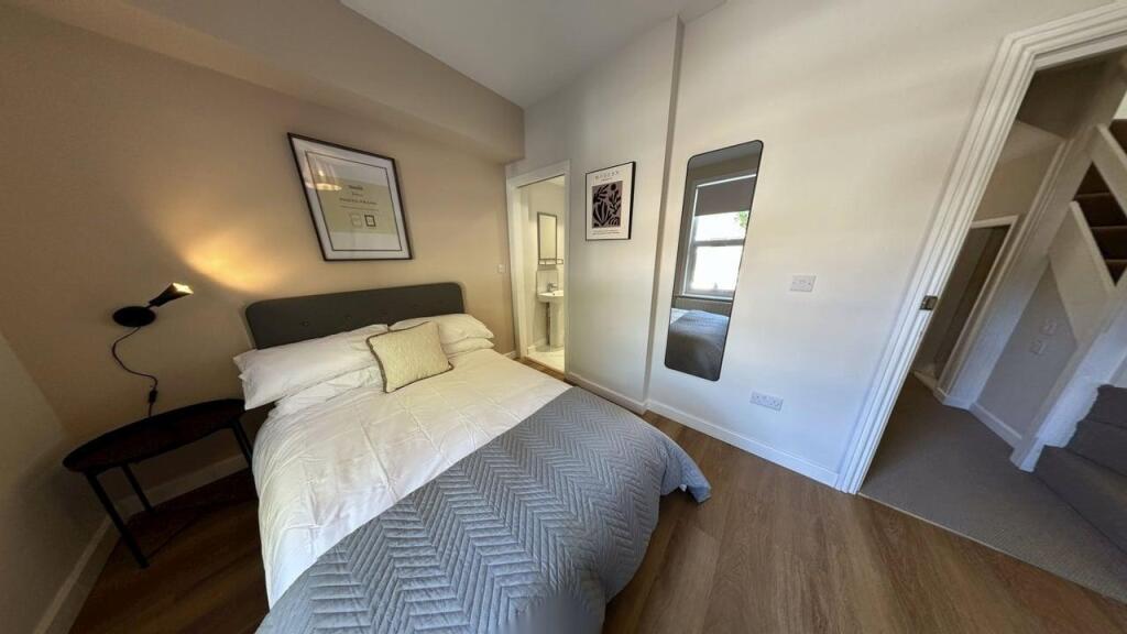 A well-lit, cozy double bedroom featuring a com...