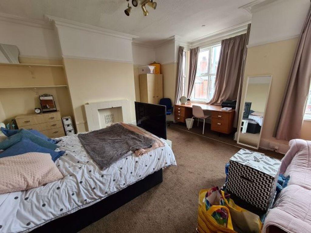 A spacious master bedroom featuring a comfortab...