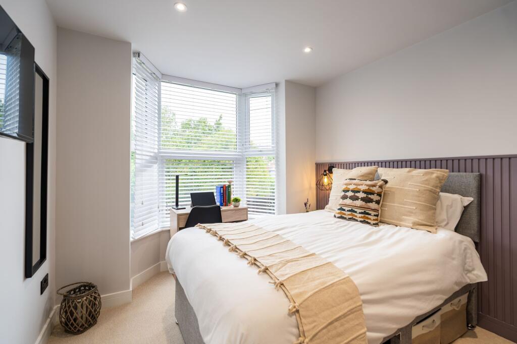 A bright and inviting bedroom featuring a large...