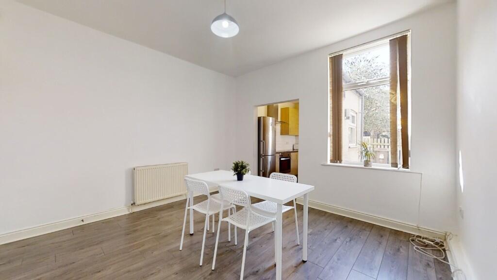 Bright kitchen area with clean white walls, woo...