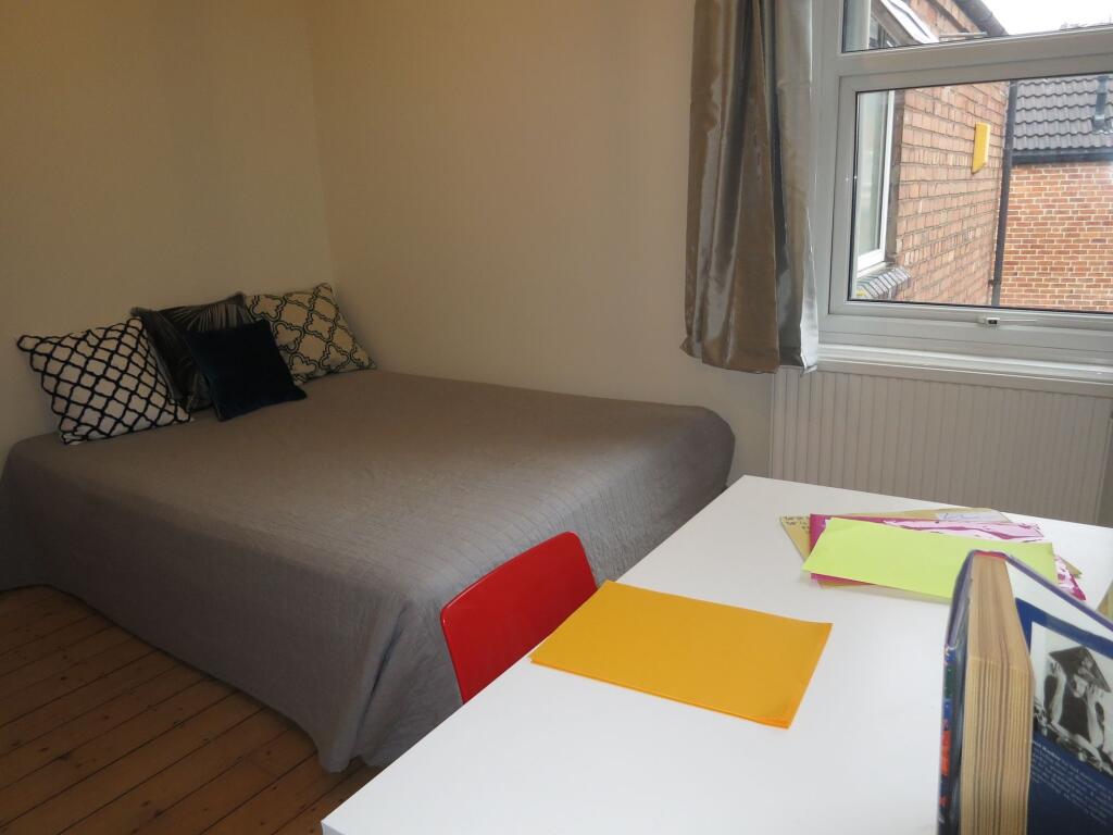 A spacious and well-lit bedroom featuring a com...