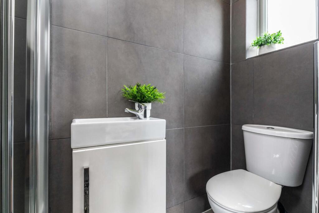 Modern and tidy bathroom with a white toilet an...