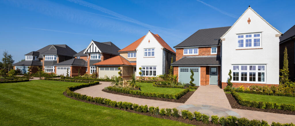 Modern detached houses with well-kept gardens and colourful lawns under a clear blue sky at Newton G