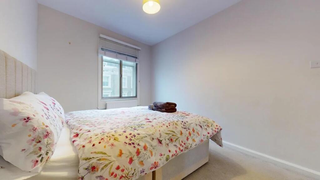 A bright and tidy double bedroom featuring a co...