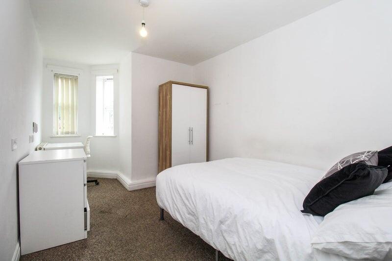 A neat and functional single bedroom featuring ...