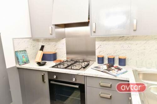 A modern kitchen featuring sleek grey cabinetry...