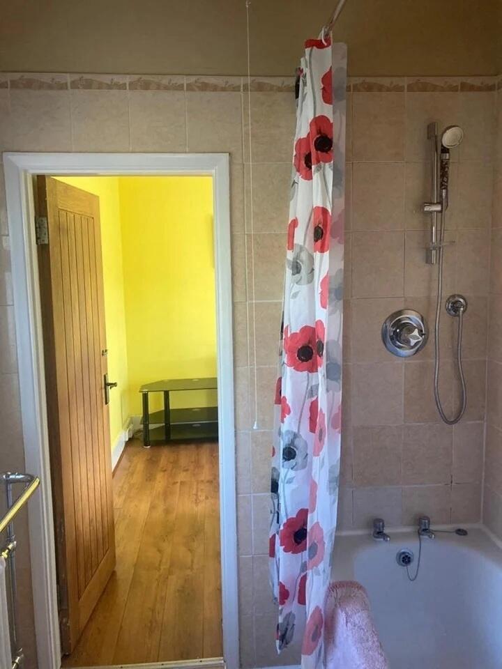 A bright bathroom suite featuring a bathtub wit...